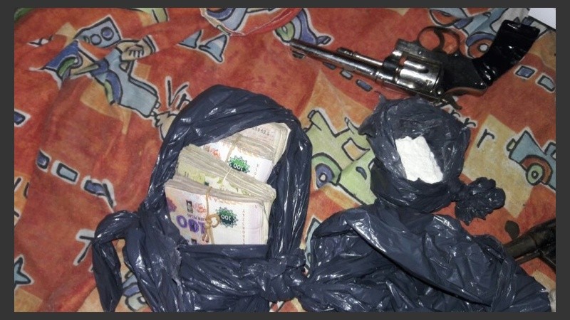 Dinero y armas secuestrados en el allanamiento. 