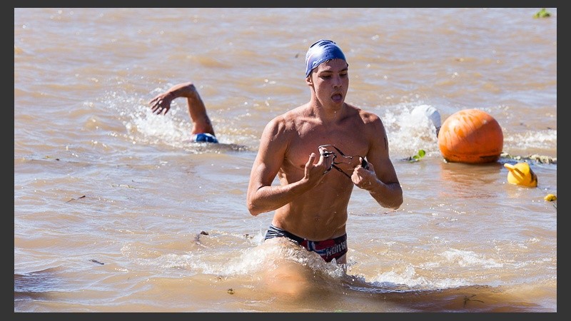 Uno de los nadadores sale del agua. Lo espera una larga corrida por la arena.