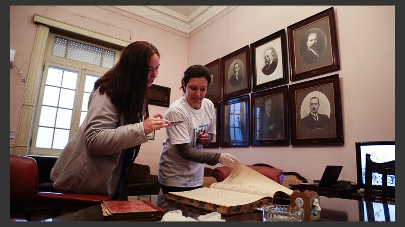 Dos mujeres revisan material de archivo de la Sociedad Rural Argentina en el edificio de Córdoba 1826.