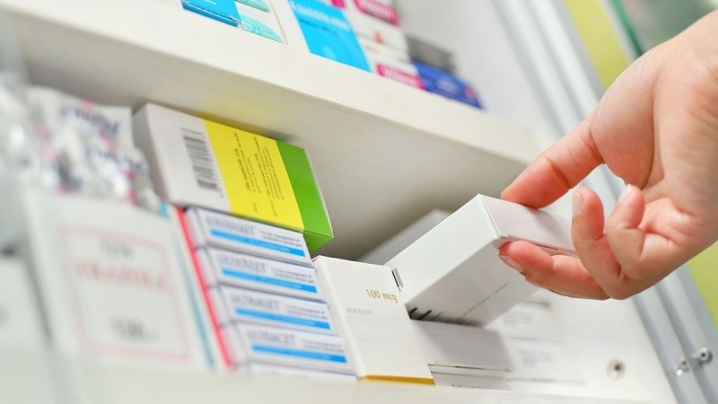 Closeup pharmacist hand holding medicine box in pharmacy drugstore.-Not Released (NR)