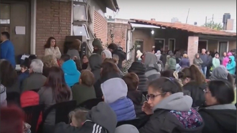 Decenas de fieles bajo la lluvia y abrigados esperaban ingresar en la capilla.