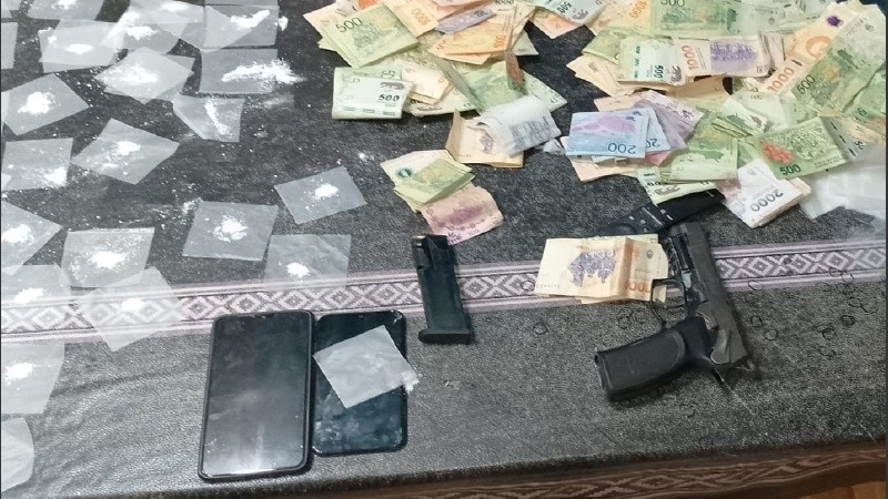 En la mesa del comedor hallaron un arma, dinero y paquetes de droga fraccionada para la venta.