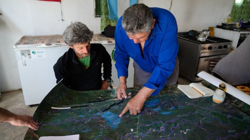 Lisandro Arelovich, autor del mapa con los ríos y lagunas, con Florencio Montero, de la asociación de pescadores.